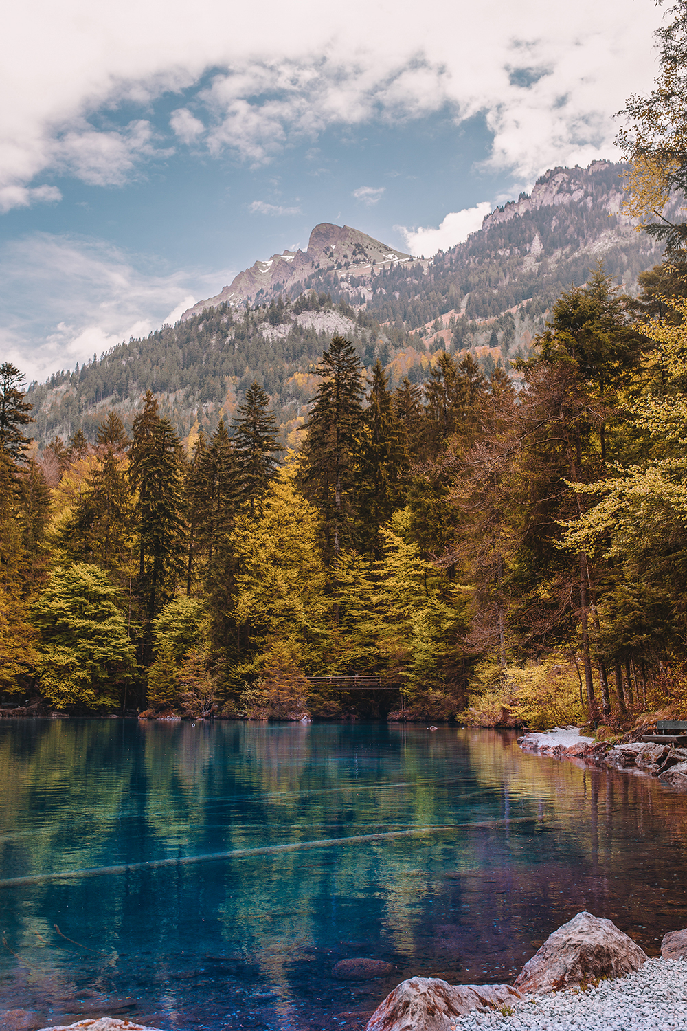 The stunning blue waters of Lake Blausee, Switzerland with the Swiss Alps in the background.