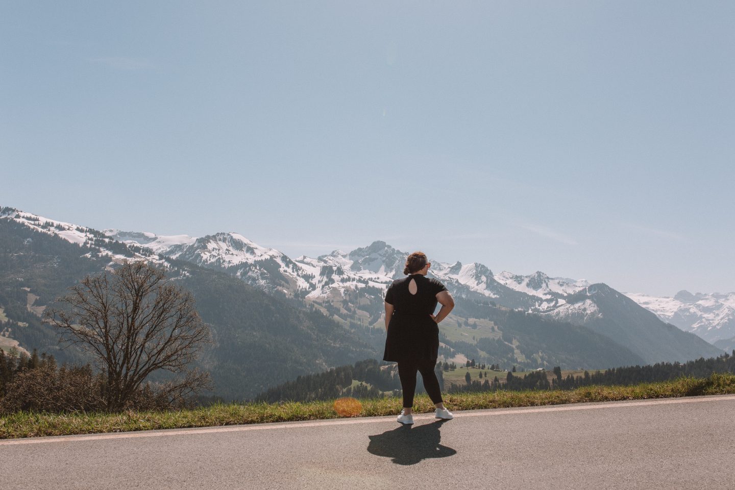 A solo female traveler admiring the snow-capped mountain views of the Swiss Alps.