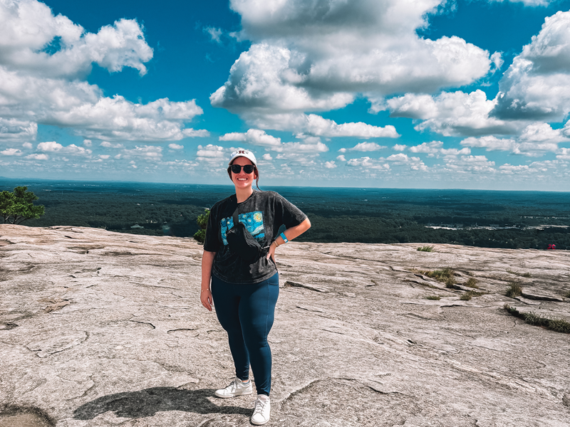 Woman on top of Stone Mountain, GA with scenic view and sky with clouds. Weekend Getaway to Stone Mountain