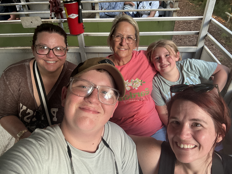 family of 5 riding (3 adult women, one boy and one girl) riding the Stone Mountain Scenic Railroad. 